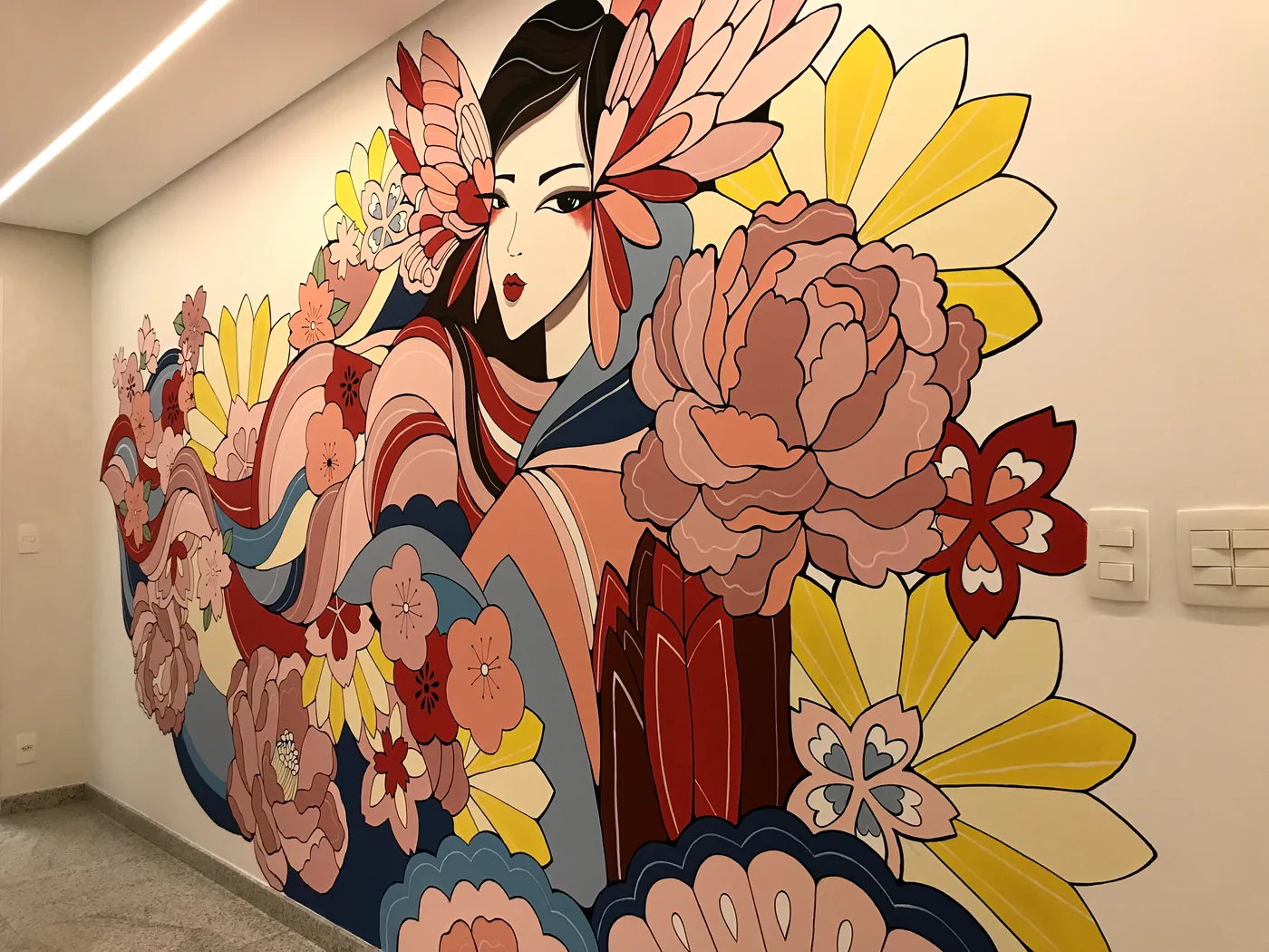 Mural japonês colorido, com uma figura feminina e flores, na parede da clínica