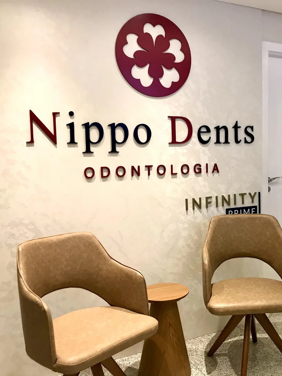 Recepção da Nippo Dents, em São Judas, com o logotipo na parede e poltronas na área de espera